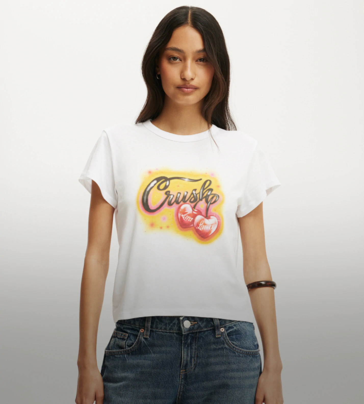 White tee with graphic a yellow background graphic desing, black text reading 'crush' and two glossy cherries reading 'Zara Larsson'.