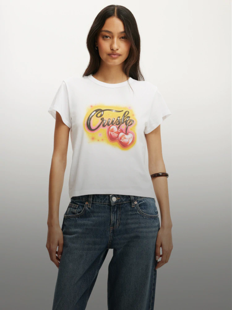 White tee with graphic a yellow background graphic desing, black text reading 'crush' and two glossy cherries reading 'Zara Larsson'.