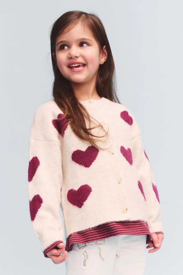 Young girl with long brown hair smiling, wearing brown leopard print hoodie with pink star design and number 89