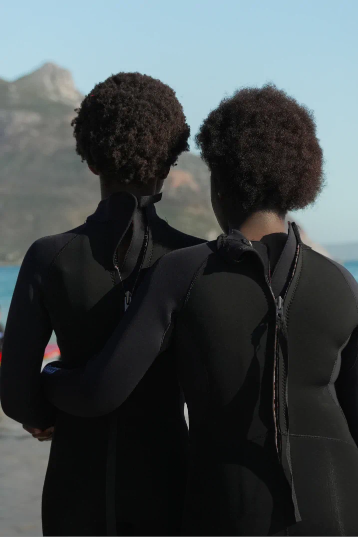 Two men getting read to dive in wetsuits.