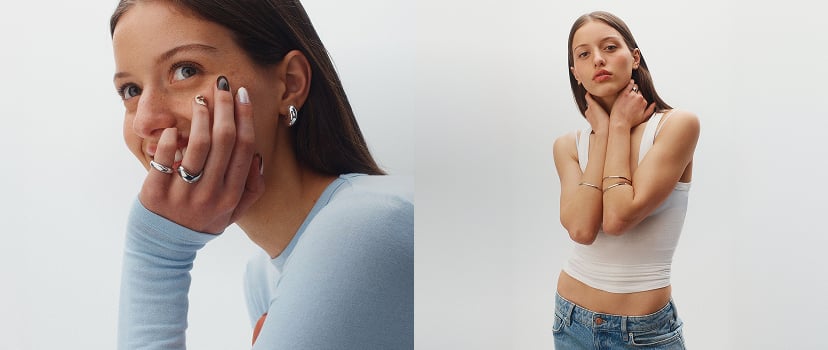 Two women modeling jewelry and accessories against a white background, displaying rings, bracelets, and earrings in silver and gold tones