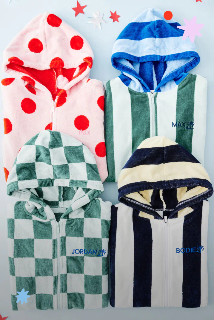 Four colorful children's hoodies displayed flat lay: pink polka dot, blue striped, green checkerboard, and navy striped styles with coordinating hoods