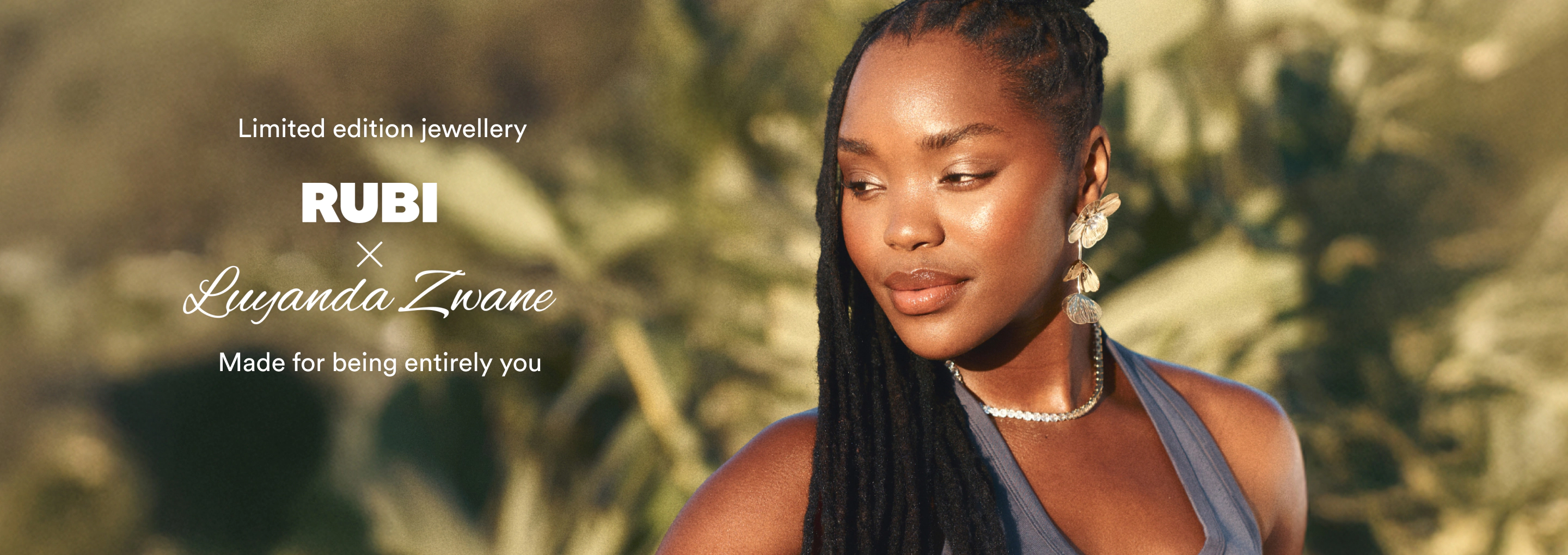 Woman wearing dangling pearl earrings and a diamond necklace against a blurred natural background. Text reads "Limited edition jewellery RUBI × Luyanda Zwane Made for being entirely you