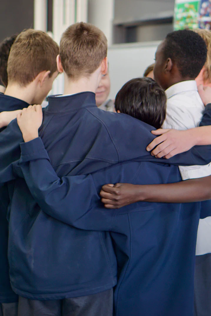 Students in a classroom wearing lab coats learning science.